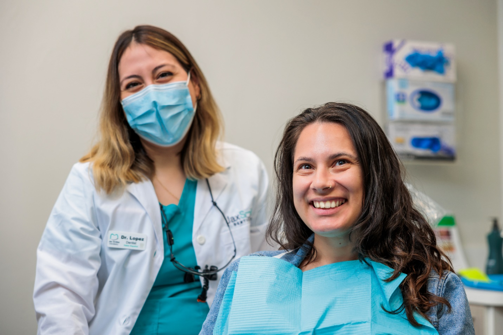 A satisfied female patient posing for a photograph with Dr. Elssy Lopez