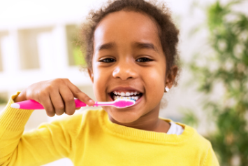 A young girl brushing her teeth.