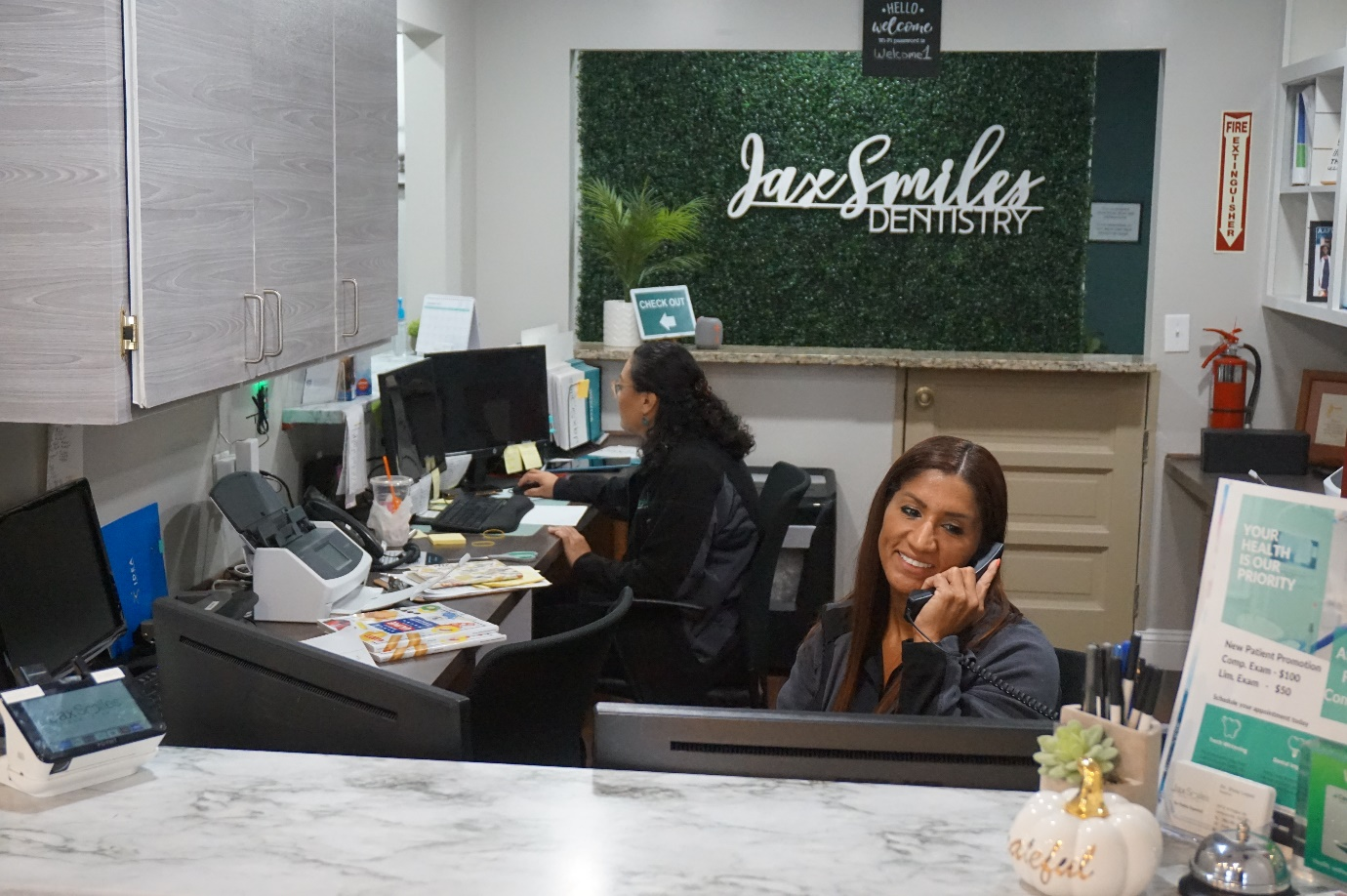 A receptionist at Jax Smiles Dentistry smiling while on call.