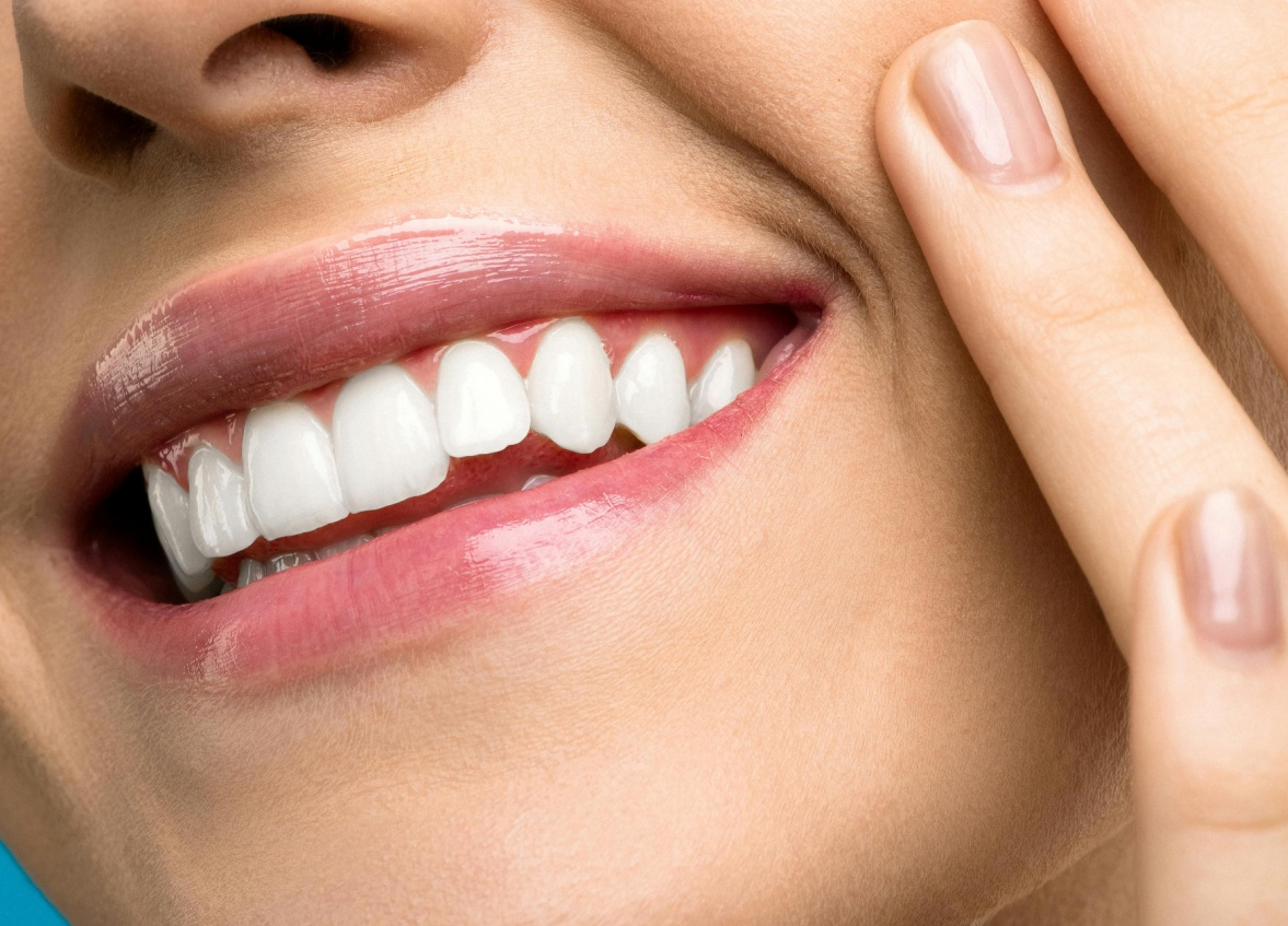 A smiling woman wearing pink lipstick.